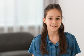 Portrait of beautiful little girl indoors, space for text