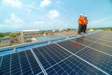 engineer man inspects construction of solar cell panel or photovoltaic cell by electronic device. Industrial Renewable energy of green power. factory worker working on tower roof.