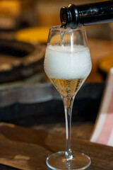 Tasting of grand cru sparkling brut white wine with bubbles champagne by old champagne caves in grand cru wine producer small village Cramant, Champagne, France