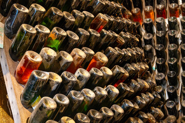 Visit of old champagne caves in grand cru wine producer small village Cramant, Champagne, France. Dusty champagne bottles on pupitre riddling rack.