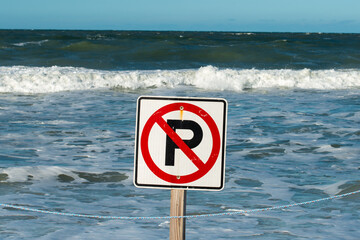A white square sign with a red round circle and the letter p in black paint. The signage is on a...
