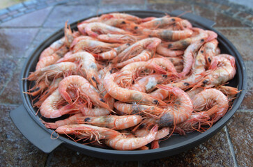 Steamed shrimps in a pan on a stone background.