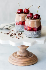 Black Forest chia puddings topped with fresh cherries and cacao nibs.