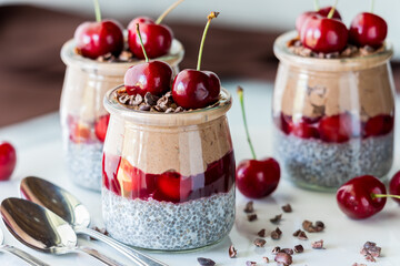 Black Forest chia puddings topped with fresh cherries and cacao nibs.