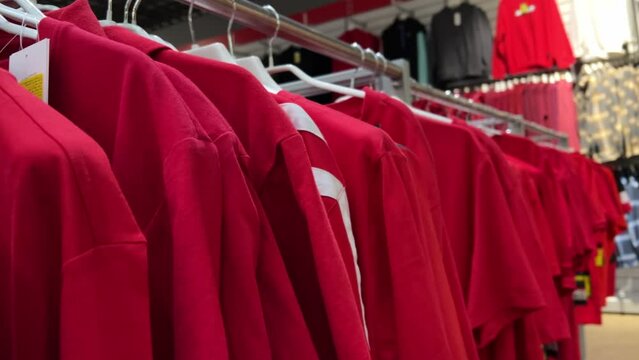 Red Sports T-Shirts: Short and Long Sleeve Jersey Collection | Athletic Apparel Store Rack Display | Fashion Merchandise Variety | Retail Sportswear Shopping
