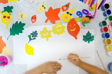 Autumn crafts. Child making colorful fun leaves from paper and plasticine. Back to school. Ideas...