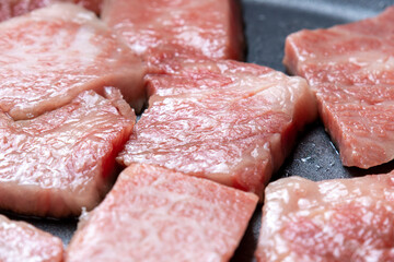 牛肉をフライパンで焼く調理シーンのアップ。
