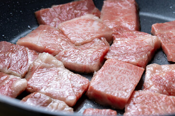 牛肉をフライパンで焼く調理シーン。
