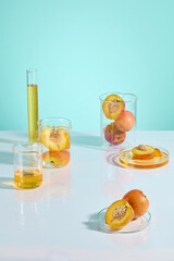Fototapeta premium Peach science experiment photograph over blue texture from high angle shot. Vacant space in the center of white countertop, decorated with glass lab utensils around, empty space for product displaying