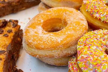 Sweet dessert variety of decorated donuts cakes in confectionery shop