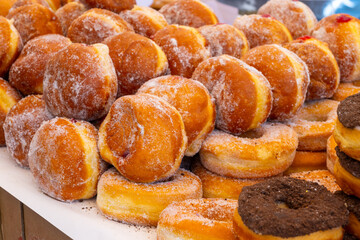 Stuffed Berlin balls with cream or fruit jam for sale on food market