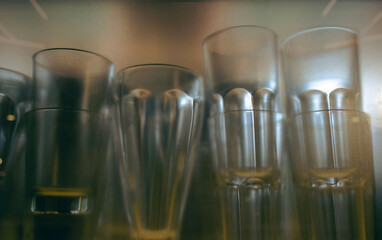 set of different glasses behind a translucent glass