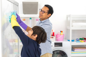 Family asian father and kid little boy son doing household cleaning and washing in protective...