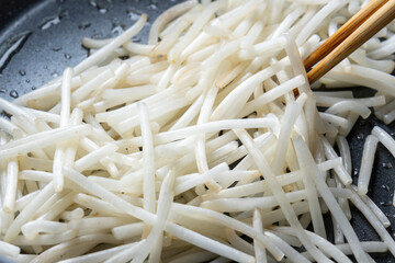 もやしをフライパンで炒める調理シーン。
