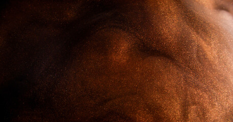Glitter dust. Smoke splash. Ink water. Blur brown bronze golden color mist sparkling particles...