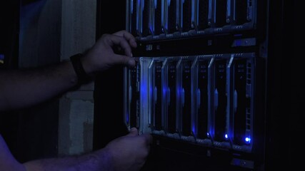 IT Engineer Inserts Hard Drive in Server Room and Enters Information Using a Flat Keyboard on Modern Screen Interface. Cluster Server Data Center. Close Up. Engineer hands.  - Powered by Adobe