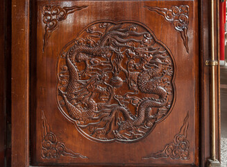 A closeup view of a detail of a carved door at a Buddhist Temple showing a stylized dragon_05252008_0024.