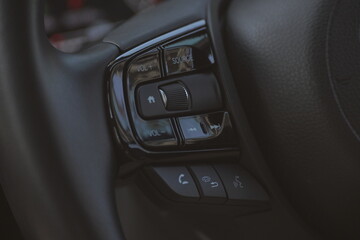 interior view of car with black leather, close up steering wheel with button