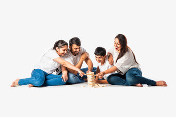 asian indian young family enjoying playing wooden block stacking game at home