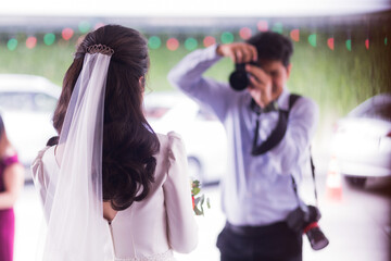 ฺBride being photographed by a photographer at a wedding