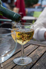 Tasting of Bordeaux white wine, right bank of Gironde Estuary, France. Glasses of white sweet French wine served in outdoor restaurant