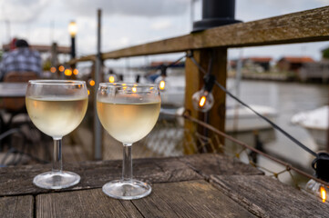 Tasting of Bordeaux white wine, right bank of Gironde Estuary, France. Glasses of white sweet French wine served in outdoor restaurant on oysters farm in Gujan-Mestras, Arcachon bay