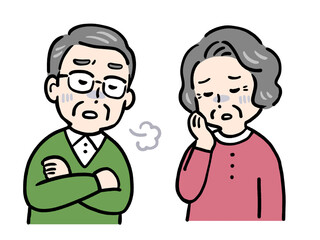 悩んでため息をつくシニア夫婦