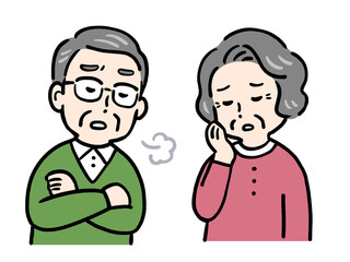 悩んでため息をつくシニア夫婦