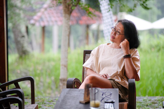 Asian woman sitting alone at home veranda waiting for someone