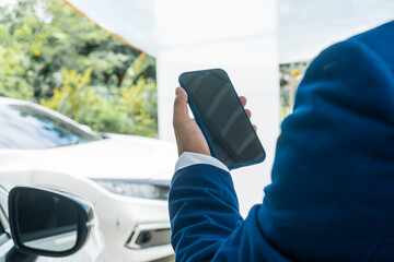 A businessman stands next to his damaged vehicle after an accident, holding a clipboard and...