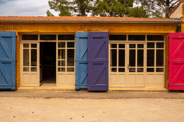 Colorful louvre doors on the building of the Écomusée De L'ocre, the former ochre factory in...