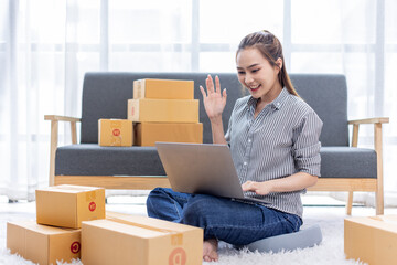 asian young woman owner packing product box prepare to the package for delivery to the customer on sofa at home office asian Entrepreneur SME business concept.