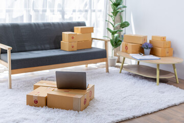Parcel boxes on shelf and color shopping bags placing near laptop on table. SME business on...