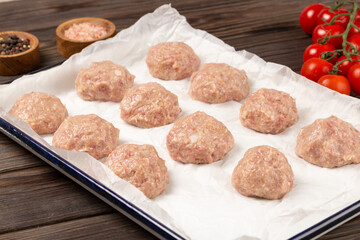 Raw meatballs on a baking sheet