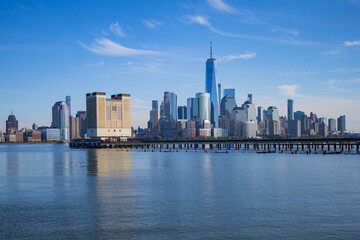 Fototapeta premium The city skyline of New York City in USA, United States. Blue sky day with iconic buildings. New York City NYC Manhattan Downtown Skyline, viewed from Jersey City, USA.