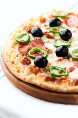 Pizza with salami, jalapeno pepper and black olives. Home made food. Concept for a tasty and hearty meal. Close up.	