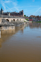 View.on old part of town of Gien on the Loire river, in Loiret department, France, houses with tiled roofs and chimneys, castle and bridge