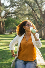 Fototapeta premium Afro-Latin woman with healthy lifestyle, enjoying a green drink