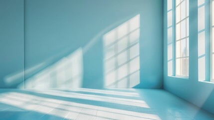 Obraz premium An empty room filled with sunlight streaming through large windows, casting geometric shadows on the floor.