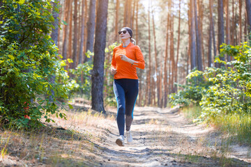 young girl on a morning run in a sunny pine forest