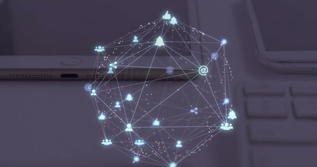 Image of globe of digital icons spinning over close up of laptop, diary and tablet on a table