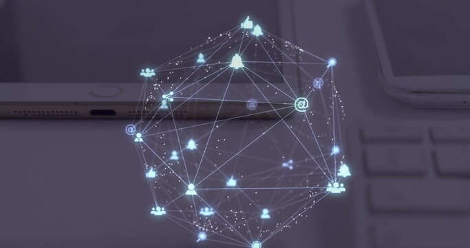 Image of globe of digital icons spinning over close up of laptop, diary and tablet on a table