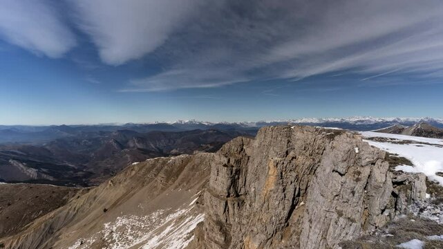 Breathtaking daytime sight of timelapse clouds swiftly moving over rugged rocky mountain summit. Panoramic views of vast alps mountain ranges in Des Monges, France. Stunning peak nature scene.