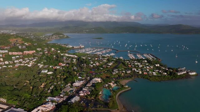 Airle Bay Beach Lagoon aerial drone Coral Sea Marina Pioneer Bay Port Cannonvale heart of Great Barrier Reef Whitsundays islands Whitehaven sunrise morning mist clouds jetty sailboats right motion