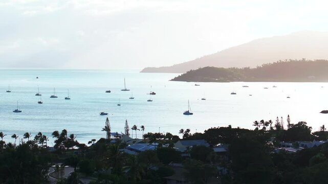 Airlie Beach Bay Lagoon gateway to Great Barrier Reef Whitsundays Whitehaven aerial drone sunrise morning mist sunny coastline marina jetty sailboats Coral Sea Marina calm water static shot