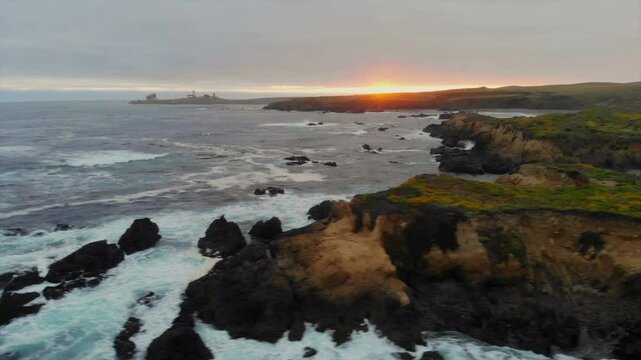 Beautiful Central California ocean cliffs, drone sweeps right to reveal majestic elephant seals nesting in cove rookery at sunset near San Simeon, Hearst Castle, Highway 1, Cambria, 4k Pro Res 422 HQ