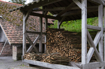 Stacked Logs Under Wooden Roof