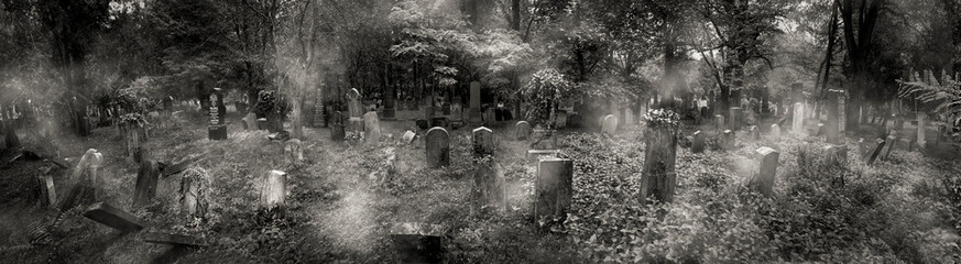 Gespenstige Szene auf einem Friedhof mit Grabsteinen, Nebelfetzen und Bäumen in der Dämmerung in...