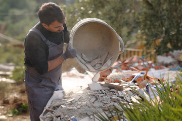 Construction worker emptying debris from carrycot