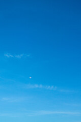 the sky is clear blue and the moon looks small